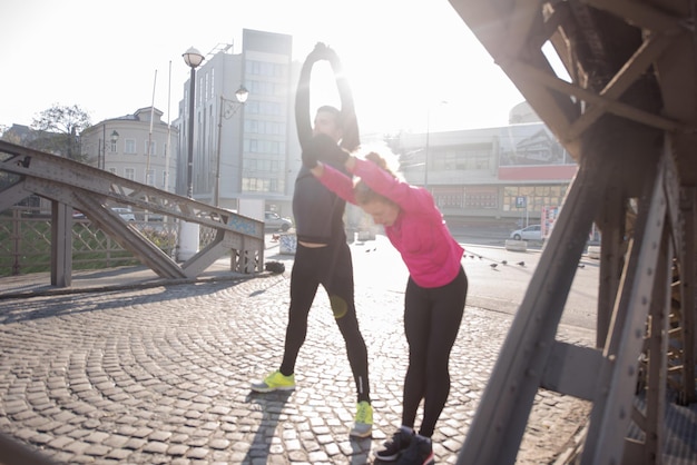 joggend paar opwarmen en strekken voor ochtend hardlopen in de stad