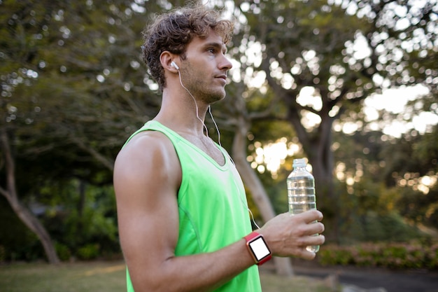 Jogger holding water bottle in park