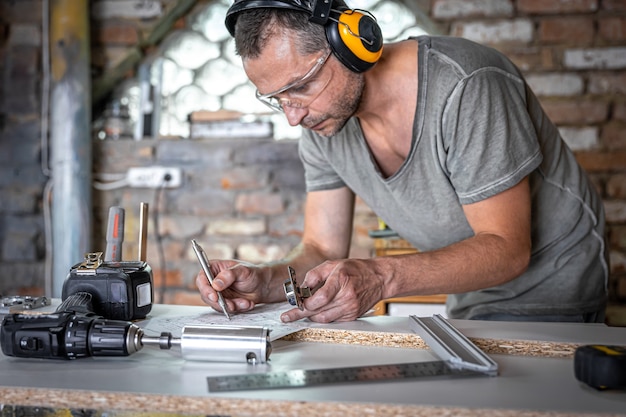 Joiner in the process of work, measurements, drilling accuracy.