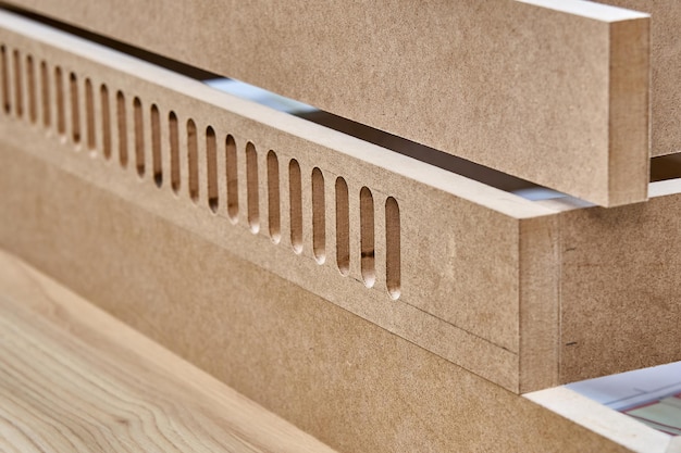 Joinery Cabinet base with ventilation holes in process of production in workshop Closeup