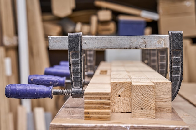 Joinery Gluing and clamping wooden detail in workshop Furniture manufacture Closeup