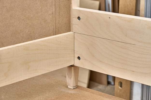 Joinery Professionally made bed of plywood and MDF in process of production in workshop Closeup