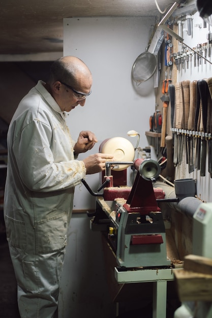 Joinery worker shaping a piece of wood on the lathe