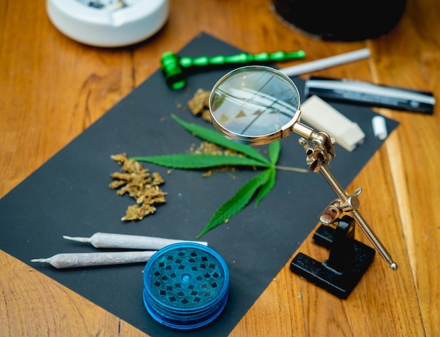 Joints and buds of medical cannabis and cigarettes on a wooden table