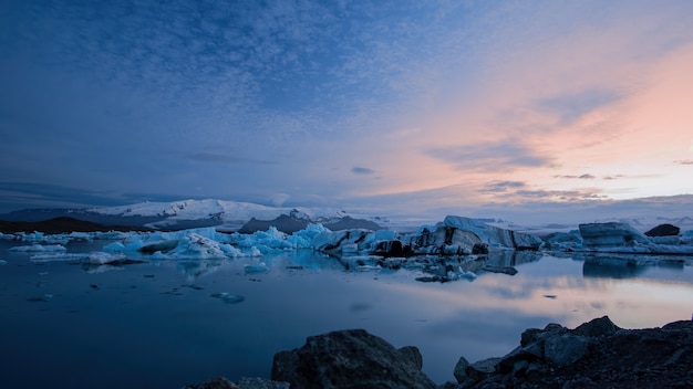 Jokulsarlon, glacier lagoon in Iceland at night with ice floating in water.