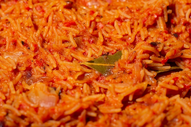 Jollof rijst close-up Achtergrond van rijst gekookt in tomatenpuree met kruiden