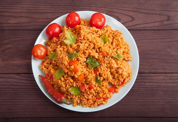 Jollof rijsttomaten en hete pepers op een blauwe plaat op een houten achtergrond Nationale keuken van Afrika