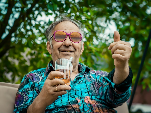 Photo jolly grandpa shows his thumb up