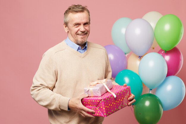 Jolly man holding birthday gifts