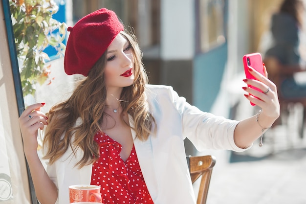 Jong aantrekkelijk Frans meisje dat selfie op mobiele telefoon maakt. Mooie dame die mobiel houdt.