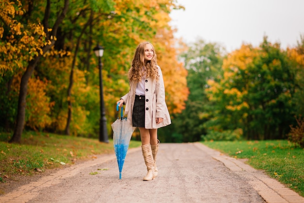 Jong aantrekkelijk glimlachend meisje onder paraplu in een de herfstbos