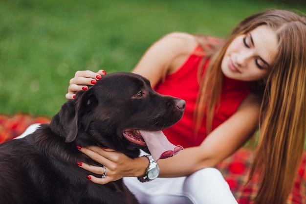 Jong aantrekkelijk meisje stroge de hond op de tuin