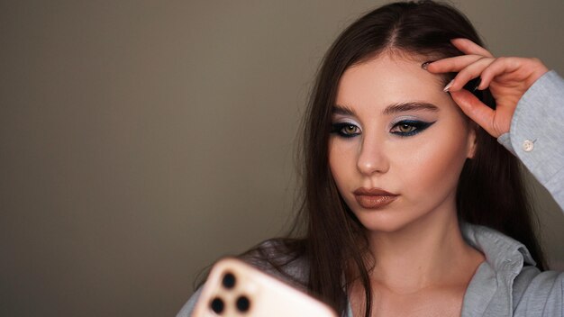 Jong aantrekkelijk model maakt een selfie na make-up in schoonheidsstudio.