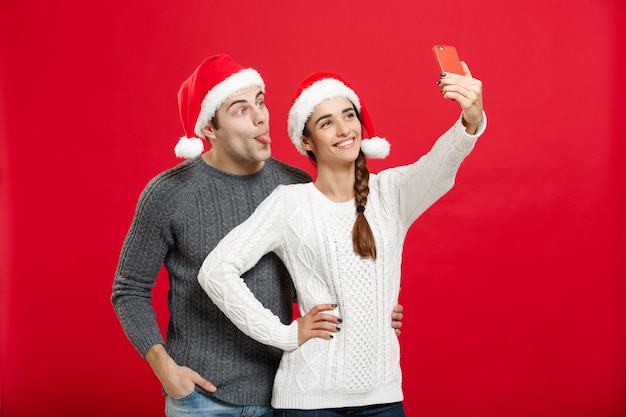 Jong aantrekkelijk paar die een selfie nemen door het mobiele telefoon vieren in Kerstmisdag.