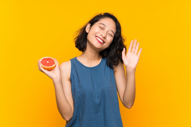 Jong Aziatisch meisje dat een grapefruit houdt