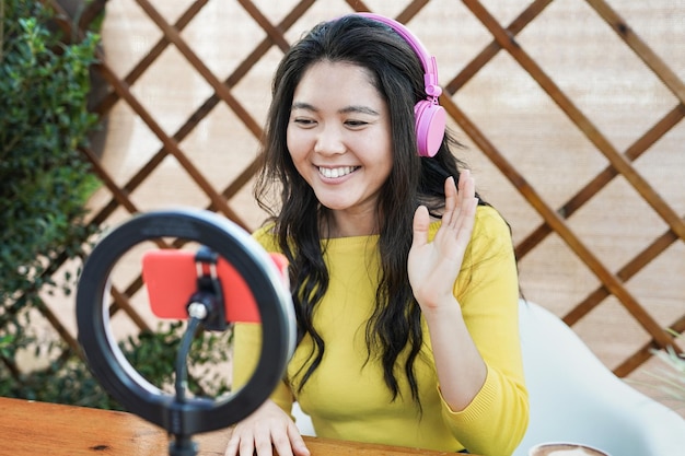 Jong Aziatisch meisje dat online video streamt met behulp van mobiele telefoon en influencer led