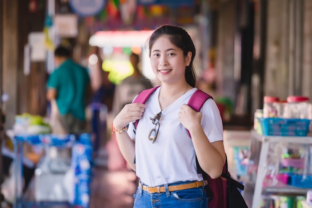 Jong aziatisch meisje die bij het drijven van dumonoe saduak markt, thailand lopen