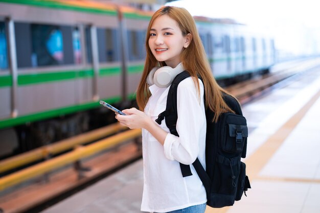 Jong Aziatisch meisje wacht op de trein op het station