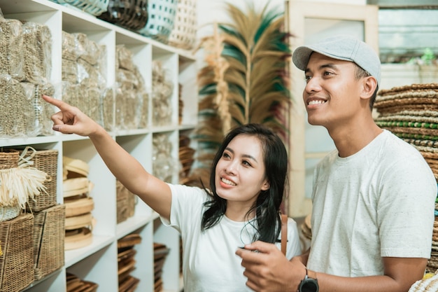 Jong Aziatisch stel zoekt en selecteert de handwerkproducten die ze willen kopen in een handwerkwinkel