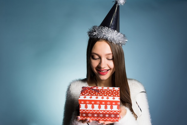 Jong blij meisje kreeg cadeau voor nieuwe voet van collega's, op haar hoofd een feestelijke pet