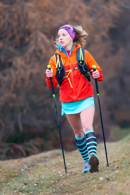 Foto jong blond meisje actieve praktijk nordic walking in een berg m