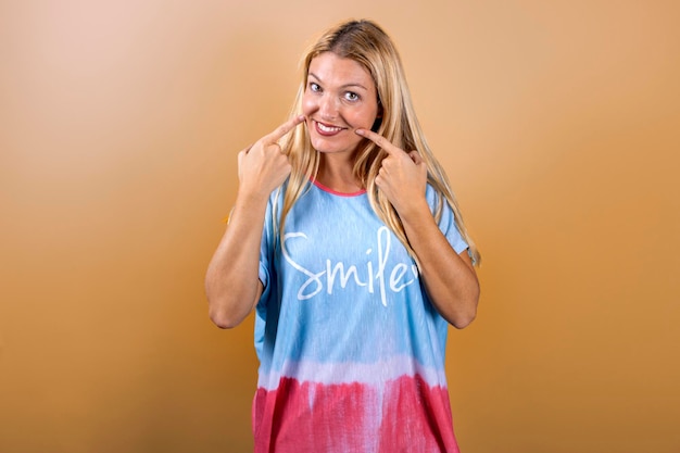 Jong blond meisje lacht naar de camera en draagt een t-shirt met de titel quotsmilquot Smile concept