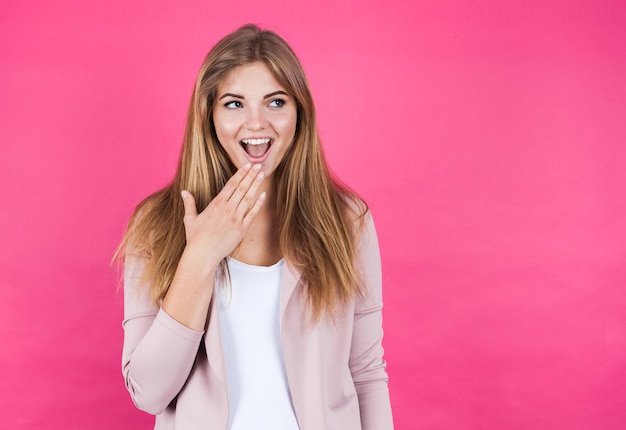 Jong blond meisje verbaasd geïsoleerd op roze achtergrond