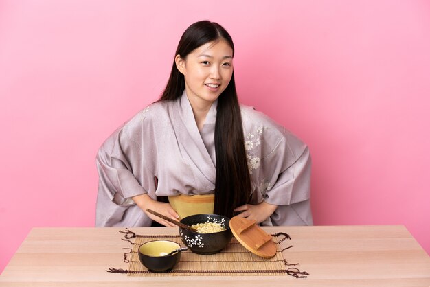 Jong Chinees meisje dat kimono draagt en noedels eet