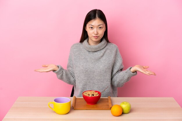 Jong Chinees meisje dat ontbijt in een lijst heeft die twijfels heeft