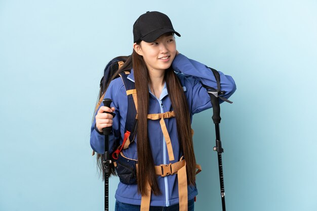 Jong Chinees meisje met geïsoleerde rugzak en trekkingsstokken