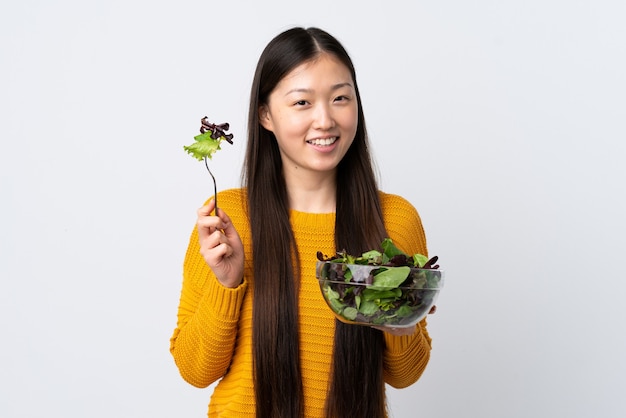 Jong Chinees meisje over wit met een kom salade met gelukkige uitdrukking