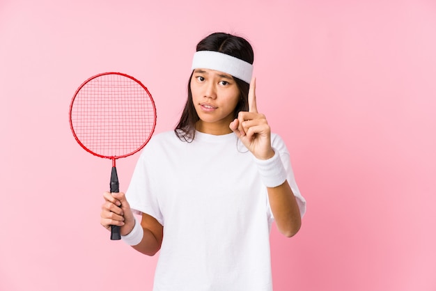 Jong Chinees vrouwen speelbadminton in een roze muur die een idee, inspiratieconcept hebben.