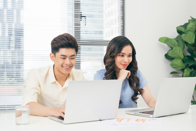 Jong commercieel team dat bij laptop, man en vrouw samenwerkt