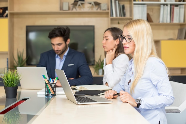 Jong commercieel team dat in modern bureau werkt