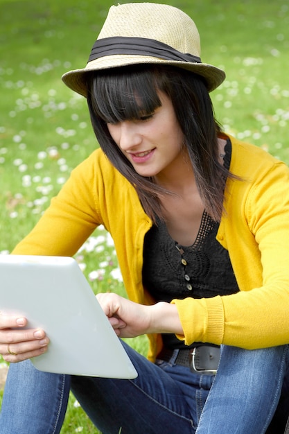 Jong donkerbruin meisje met een tablet in buiten park