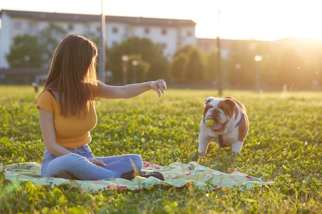 Jong donkerbruin spel met haar Britse buldog