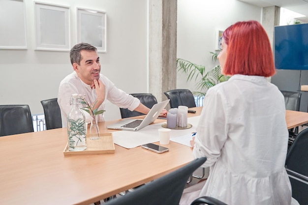 Foto jong echtpaar dat werkt bij een brainstorming bijeenkomst bedrijf in een coworking kamer