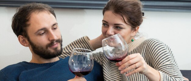 Foto jong en gelukkig stel dat wijn drinkt en thuis ontspant