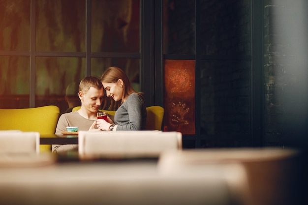 Jong en liefdevol paar zitten in een cafe