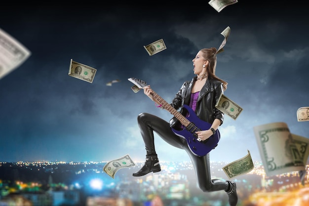 Jong en mooi rockmeisje dat de elektrische gitaar speelt. Gemengde media