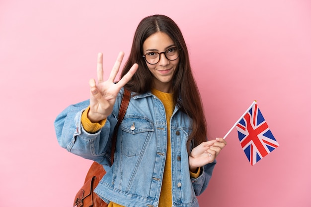 Jong Frans meisje met een vlag van het Verenigd Koninkrijk geïsoleerd op een roze achtergrond gelukkig en drie tellen met vingers