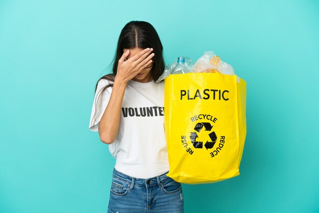 Jong Frans meisje met een zak vol plastic flessen om te recyclen met een vermoeide en zieke uitdrukking