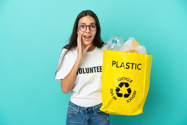 Jong Frans meisje met een zak vol plastic flessen om te recyclen met verbazing en geschokte gezichtsuitdrukking