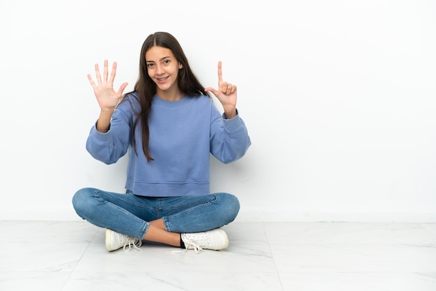 Jong Frans meisje zittend op de vloer zeven tellen met vingers