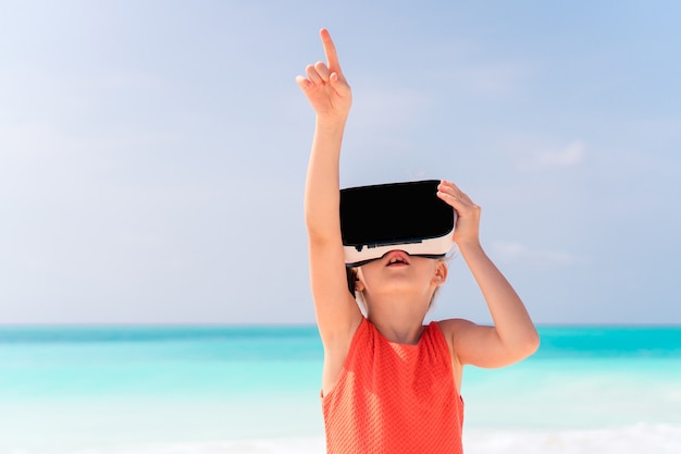 Jong geitje dat virtuele werkelijkheidsglazen op strand draagt