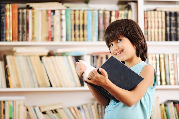 Jong geitje met boek in bibliotheek