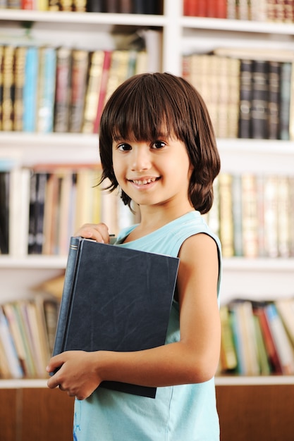 Jong geitje met boek in bibliotheek