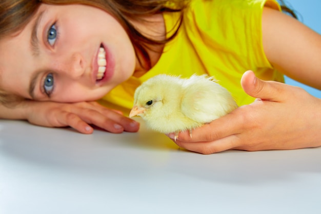 Jong geitjemeisje met kuikens die op blauw spelen