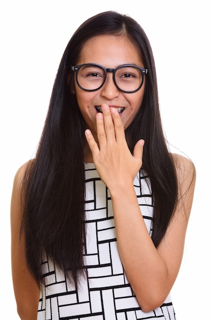 Jong gelukkig Aziatisch tienernerdmeisje dat en terwijl zij haar mond behandelt lacht lacht