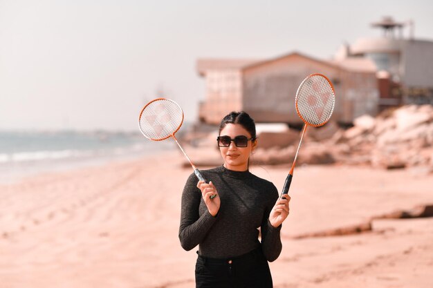 jong gelukkig meisje tennissen op strand Indiase Pakistaanse model